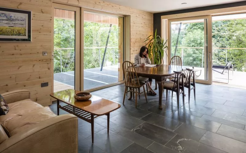 Dursely Treehouse features floor-to-ceiling glass windows, large open plan living and beautiful slate flooring