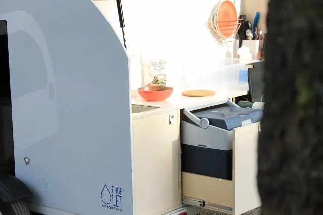 The kitchen area has a fridge, stove, countertop and storage