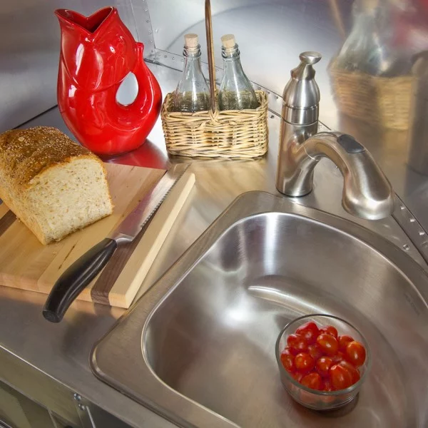 The galley is, as you would expect, compact with an SMEG Italian cooktop and a folding glass top for larger counter space