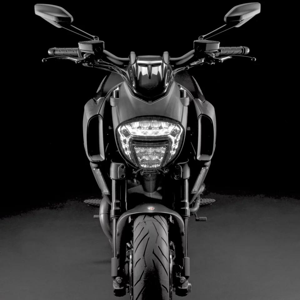 The new Diavel has a full LED headlamp to complement the characteristic twin vertical strips of LED lights, that provide tail and brake light illumination and directional indicators at the rear. The rear LED strips follow the precise line of the under-seat panelling, providing greater visibility of the rear-end while keeping the external lines of the bike clean. The front directional indicators are clear lens LED, now updated to solid strip technology mounted vertically down the leading edge of the restyled lateral radiator covers.