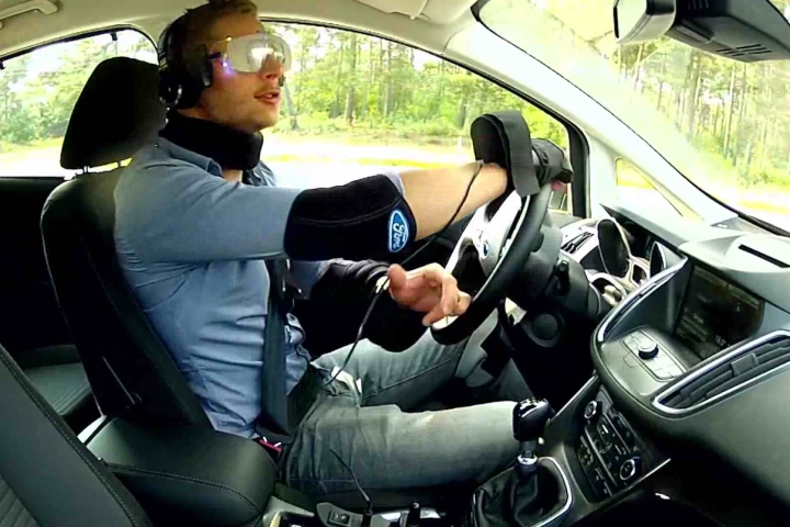 The suit uses strategically-placed weights and heavy padding reduce mobility in the arms and legs, while goggles and headphones reduce awareness