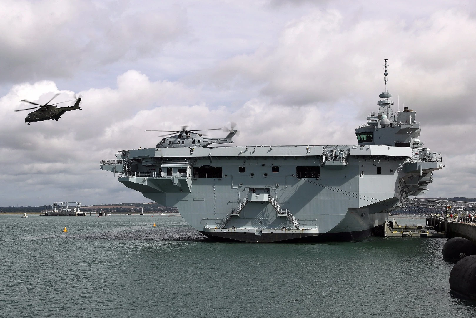 HMS Queen Elizabeth with helicopters landing and taking off