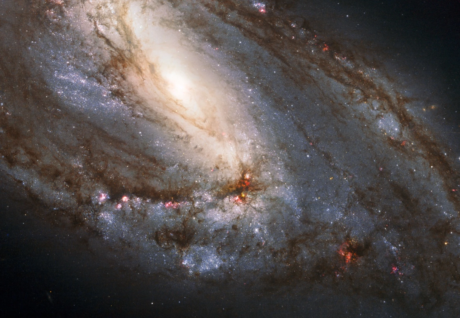 An image of the spiral galaxy M66 composed of images captured by the Hubble Space Telescope