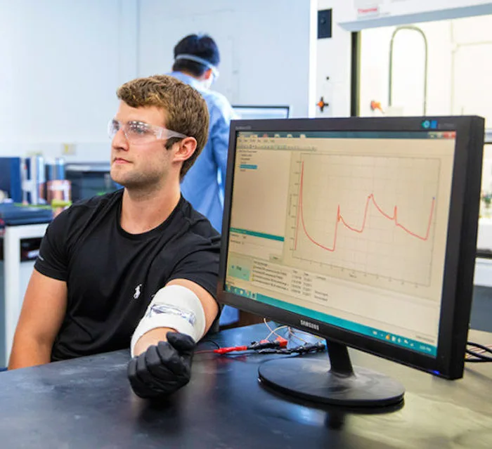 One of the researchers, Thomas Metke, hooked up to a patch of the material, and a readout of the electricity generated when he bends his elbow is visible on the computer screen