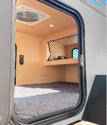 A peek in one of the entry doors shows the rear gear shelf with retention net