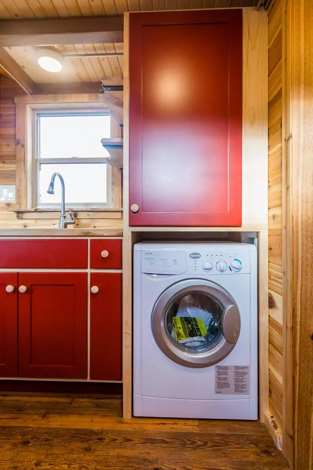 A washer/dryer is installed in Davis's 22 ft Off-Grid Tiny Home