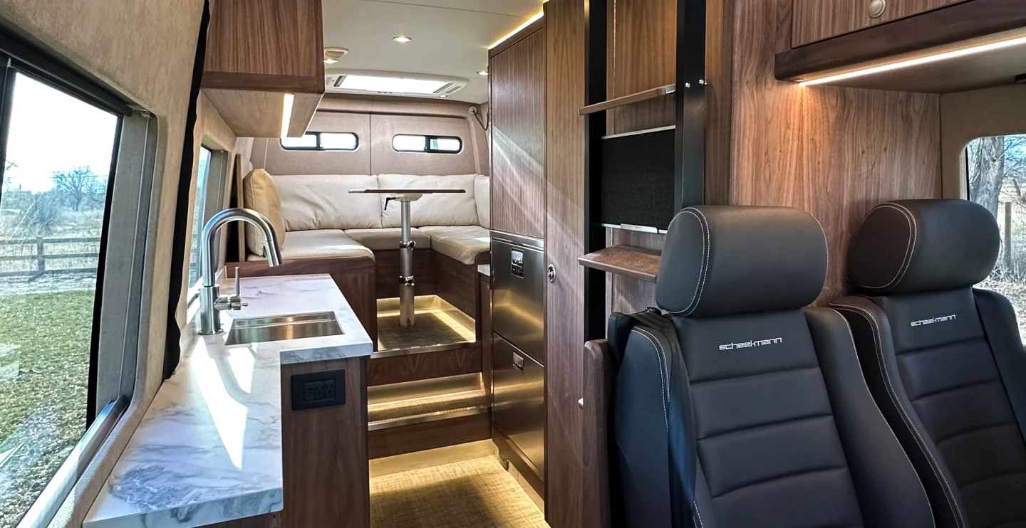 The interior features wood veneers throughout with foam-core construction for weight savings, porcelain countertops, a large rear lounge layout, and a combination of ambient and direct lighting with multicolor capabilities