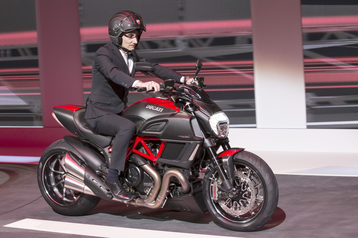 Ducati's CEO Claudio Domenicali rides the Ducati Diavel Carbon onto the stage in Geneva, putting the marque on display to the world's automotive press