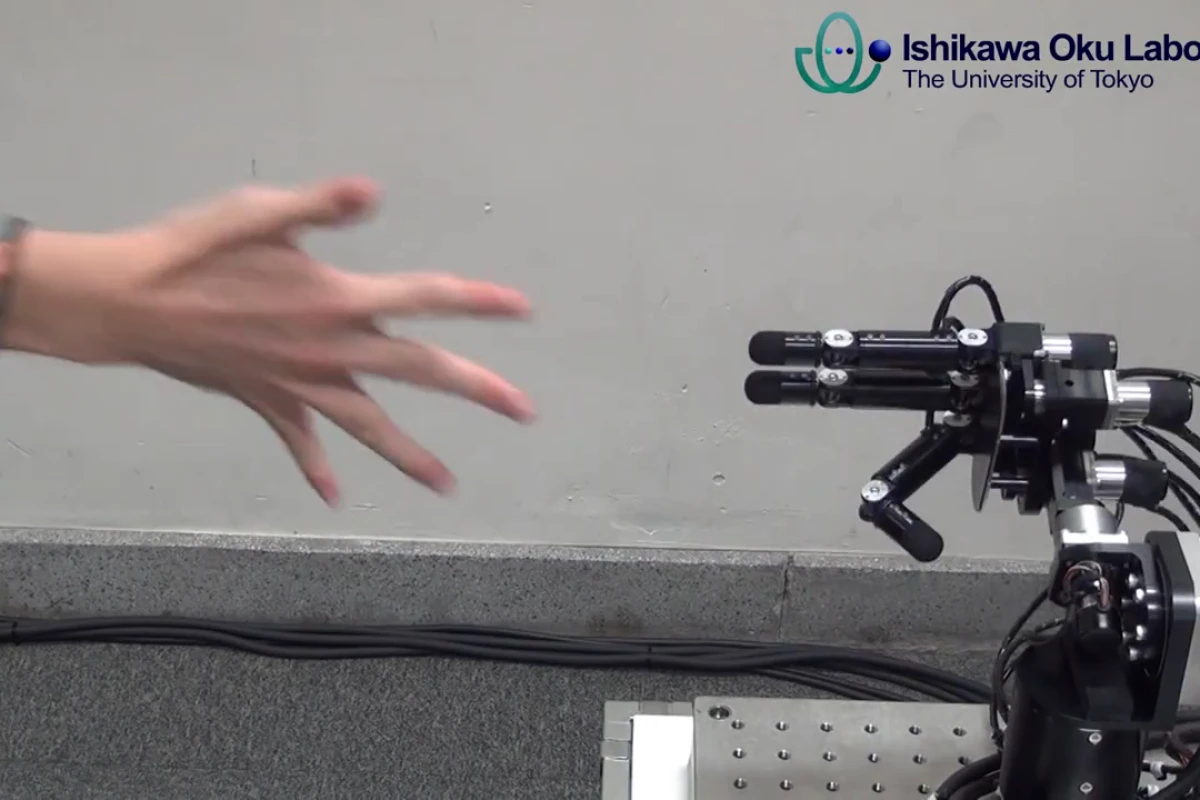 The Ishikawa Oku Lab's robot hand sticks out two fingers (scissors), beating the human (paper) in about one millisecond