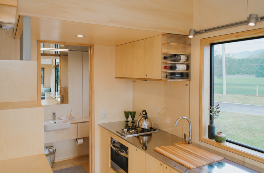 The First Light Tiny House's kitchen includes a large counter finished in stainless steel
