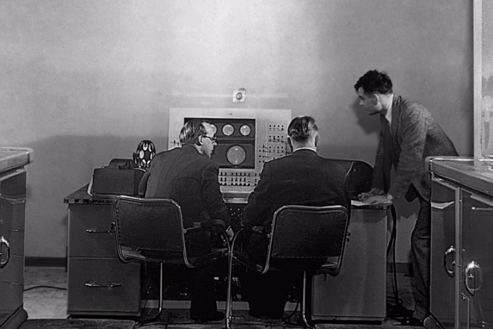 Turing (right) at the console of the Ferranti Mark I