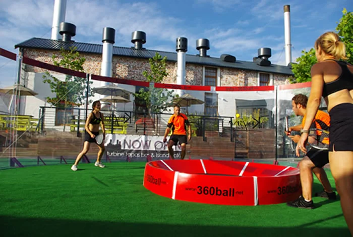 In the new racquet game of 360ball, players hit a ball into a central concave dish, trying to rebound it out of the reach of their opponents
