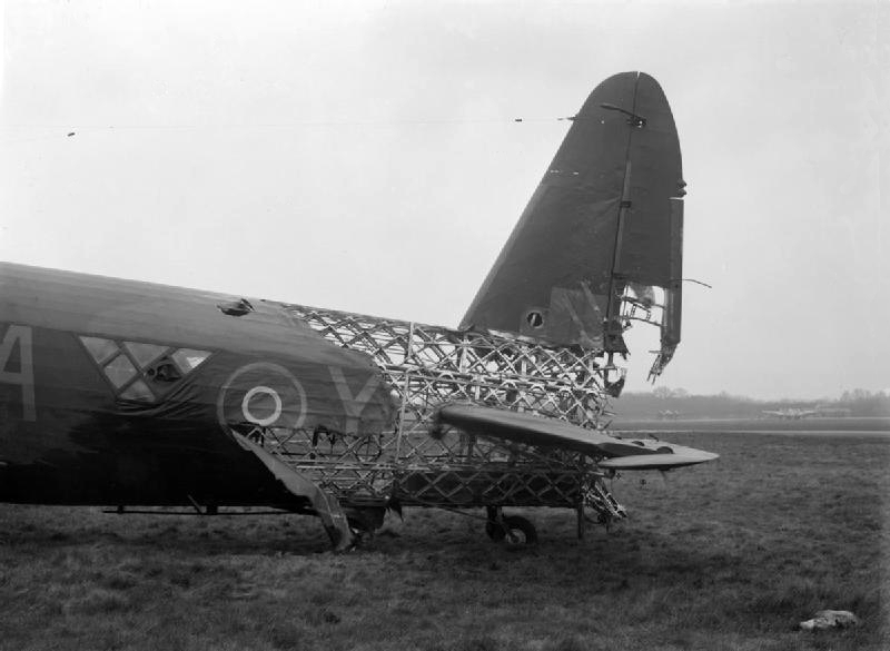 The geodetic airframe devised by Wallis in the 1930s is a basketwork structure which describes the aerodynamic form of the aircraft, as opposed to being an aerodynamic skin supported by a beam. By crossing geodesic members on a curved surface, the torsional loads on each are cancelled out, accounting for its great strength. The geodetic principle was used in the gasbag of the Vickers R100 airship, the design of which Wallis led. Geodetic design was subsequently applied to the Wellington Bomber. Though this construction method took longer than monocoque techniques, they resulted in robust aircraft. There are several accounts of Wellingtons returning safely, though rather less than intact, following raids on Germany, such as that pictured above, heavily damaged by anti-aircraft fire during a raid on Duisburg in 1943.