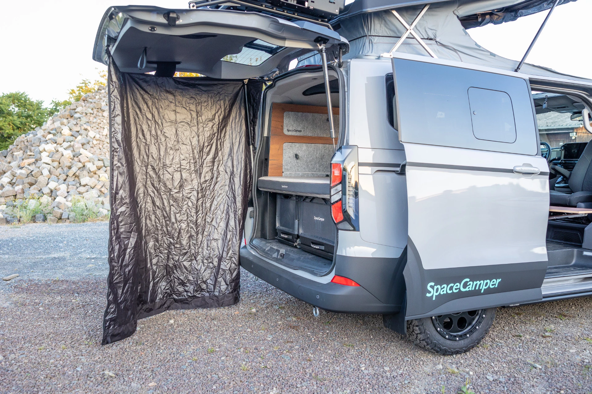 The Classic+ Ford includes a tailgate tent as a shower and changing area