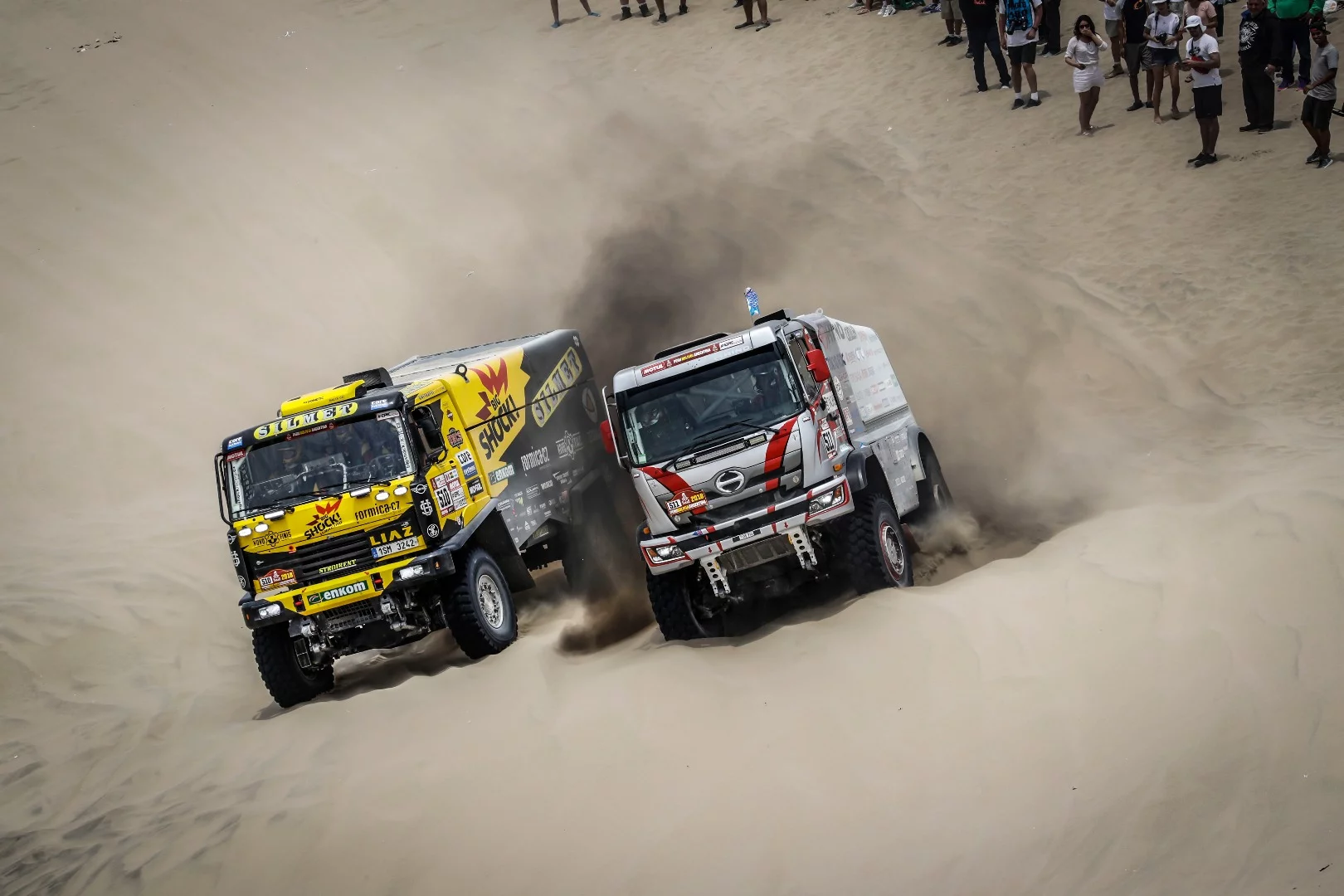 Trucks #510, a Czech team, and #511 from Japan do battle in the Peruvian desert during Stage 2
