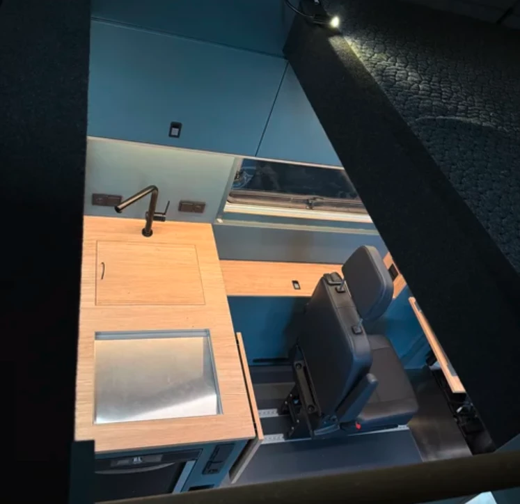 The expandable kitchen sits on the edge of the garage and can serve as both a cooking space and a workbench
