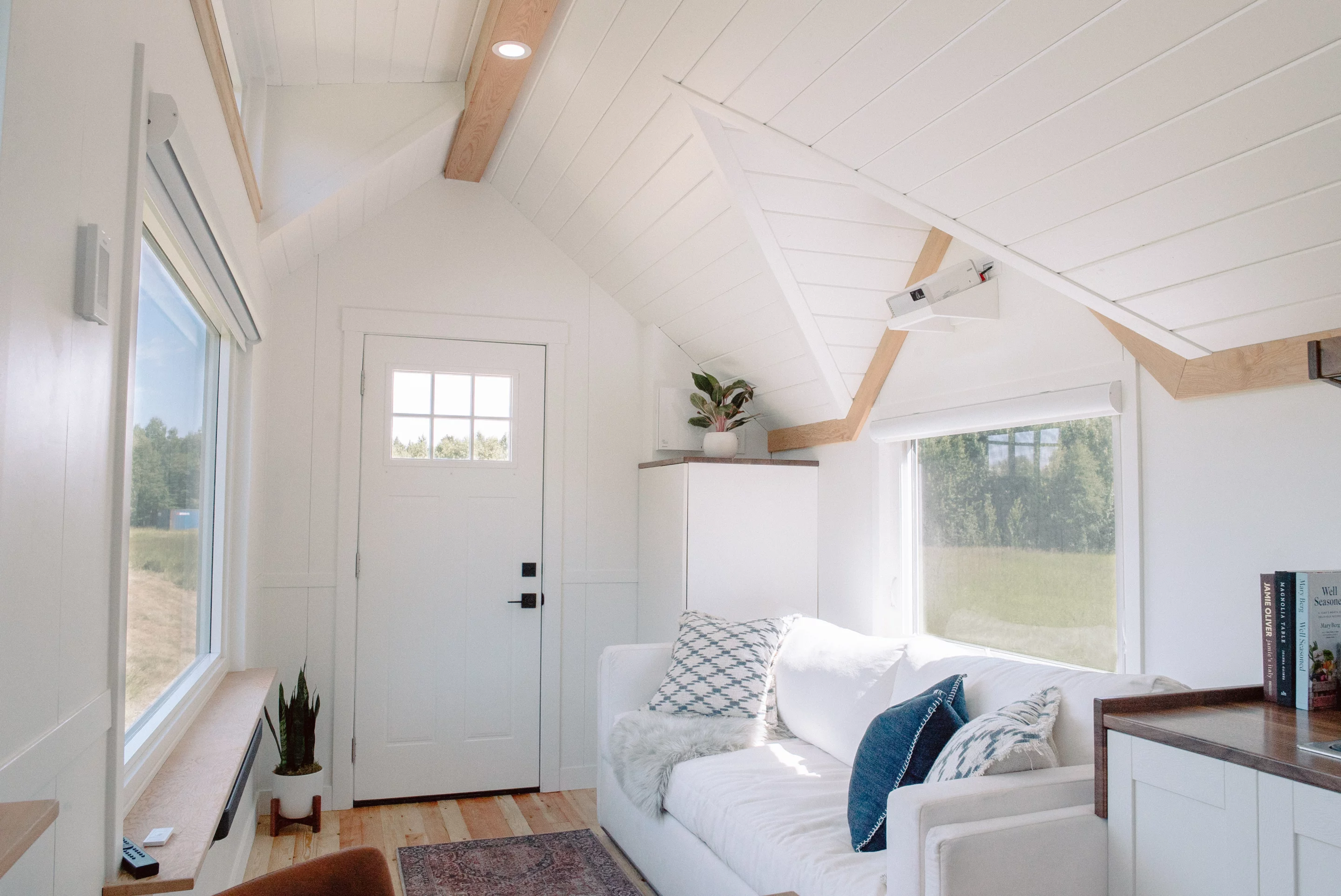 The Macdonald tiny house's living room windows can be closed with blinds, turning one of them into a large screen for watching movies with a nearby projector