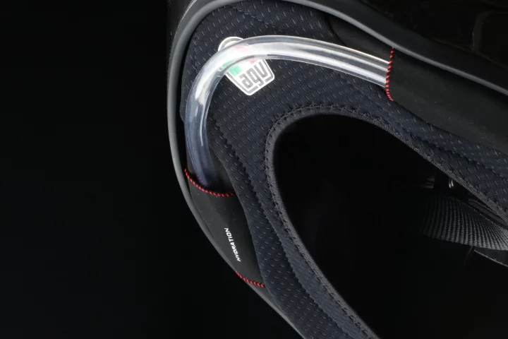 The hydration system includes an elastic tube that transports water from the back of the rider to a drinking valve built-in the helmet's chin area