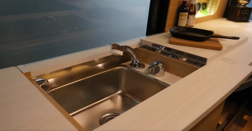 A hinged lid exposes the sink, which includes a pull-out sprayer that works as an outdoor shower