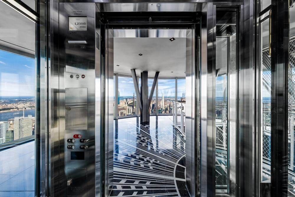 Visitors reach the top of the Empire State Building using a glass elevator
