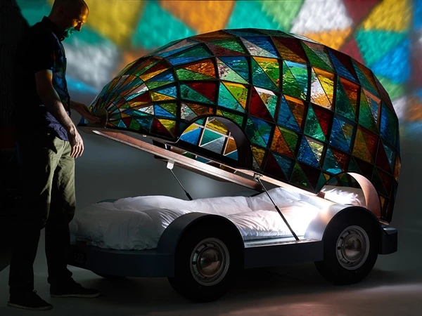 Dominic Wilcox demonstrates how the shell of the Stained Glass Driverless Sleeper Car is opened and closed (Image: Sylvain Deleu)
