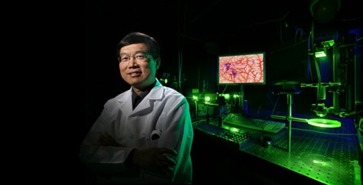 Lihong Wang with the photoacoustic imaging system built in his lab