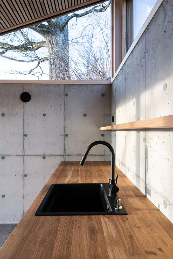 A tactile play of materials—cool concrete and rich wood—shapes this kitchen’s unique character