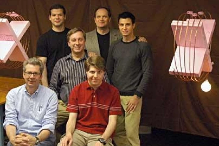Wireless power transfer over two-meter distance, from the coil on the left to the coil on the right, where it powers a 60W light bulb. Members of the team that performed the experiment are obstructing the direct line of sight between the coils; front row: