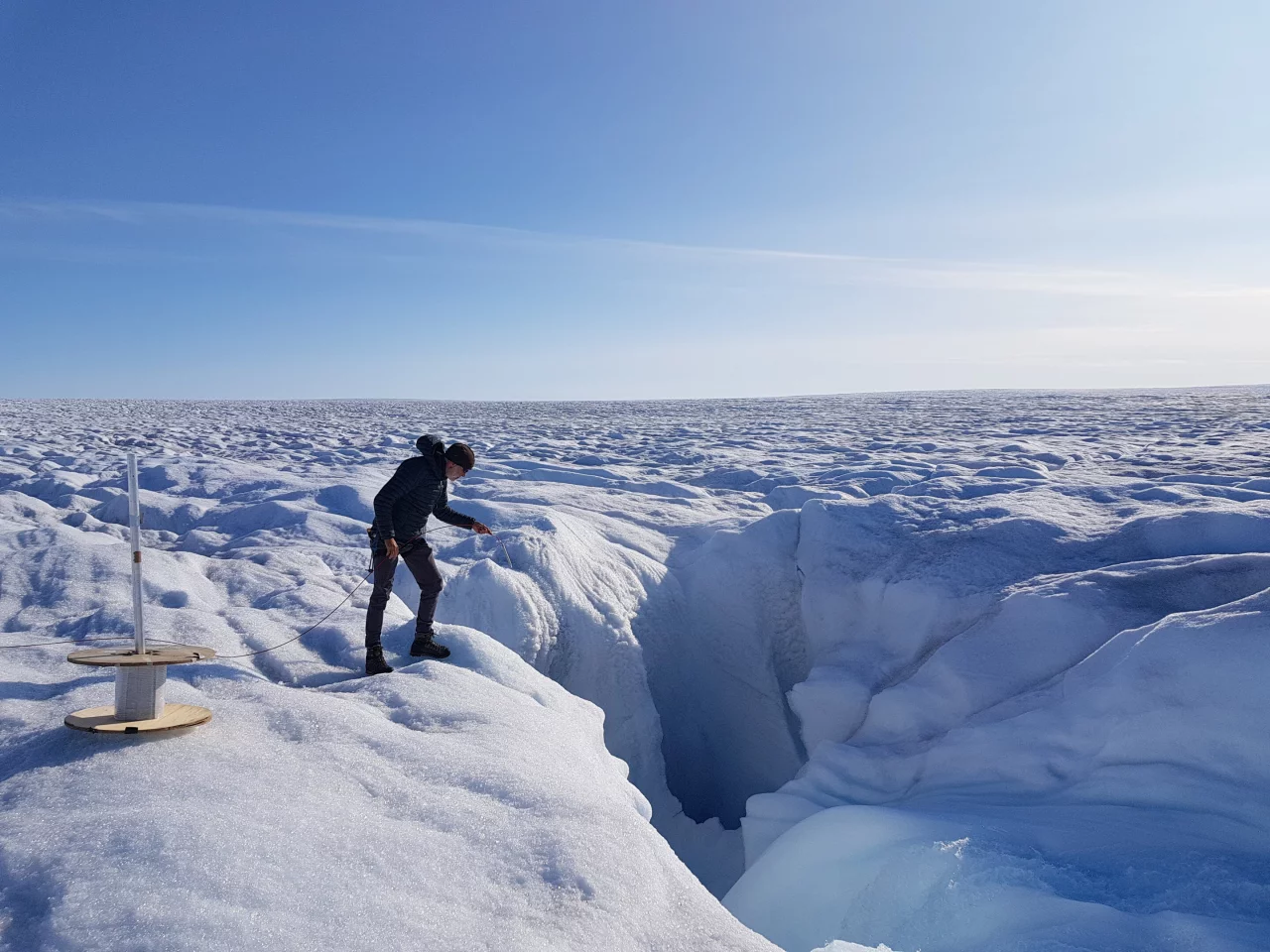 Researchers install a fiber optic cable in the Greenland Ice Sheet
