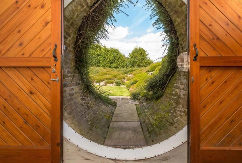 The modest sliding circular door set into the hillside offers little clue that behind it lies a large entrance hall and an expansive 4,000 sq ft (371 sq m) luxury home