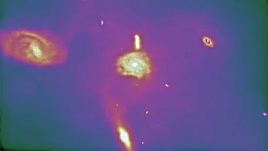 Frame from video of Universe simulation showing several spiral galaxies, an elliptical galaxy, and a peculiar galaxy (Image: Harvard-Smithsonian Center for Astrophysics)