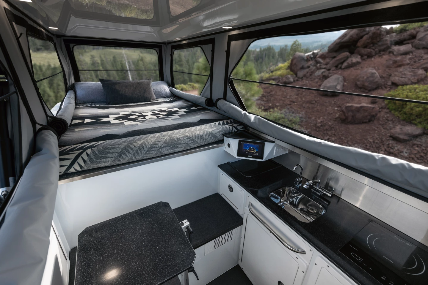 EarthCruiser makes the most out of the Hummer EV Pickup's 5-foot bed, installing a full kitchen and small L-shaped dinette below and behind the sleeper alcove