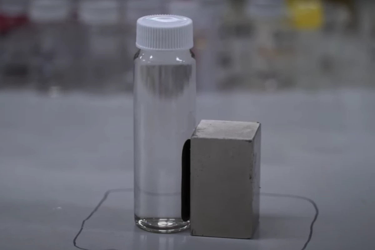 A sample of contaminated water being treated using the new technique, with the PFAS chemicals being attracted to the side with the magnet