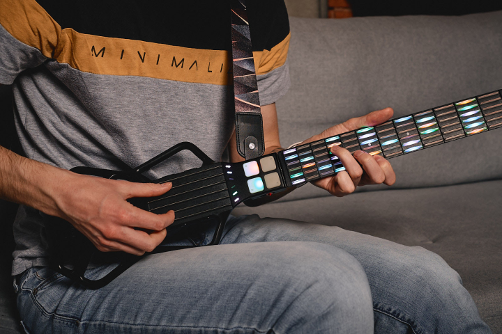 Learners can pick or strum the velocity-sensing "strings" in the deck area while fretting buttons on the neck when prompted, or opt to go freestyle