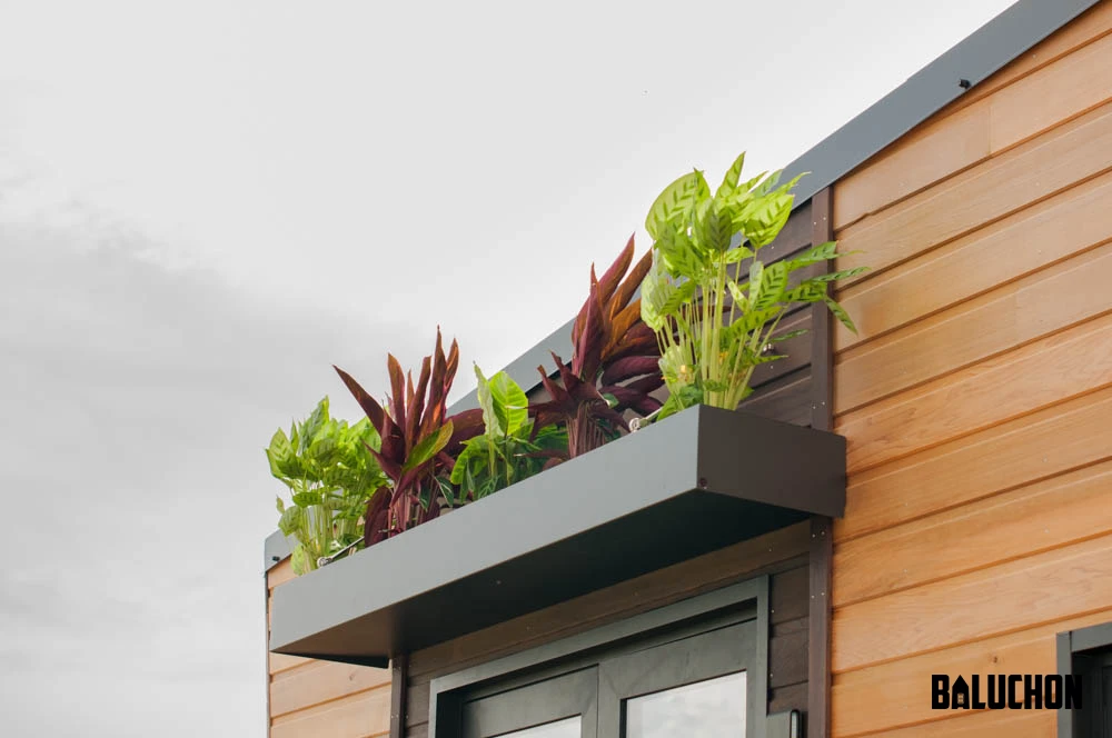 A flower box tops the entrance to the Intrépide tiny home