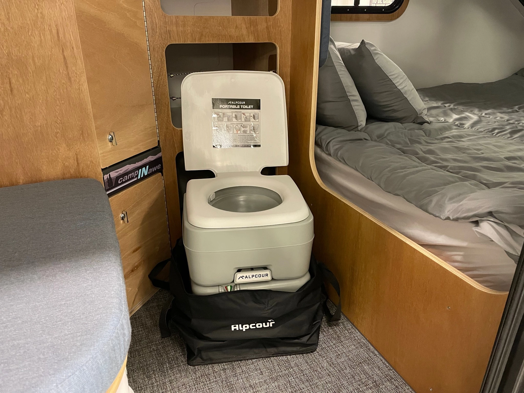 The portable toilet stores away in a lower cubby and is available when needed