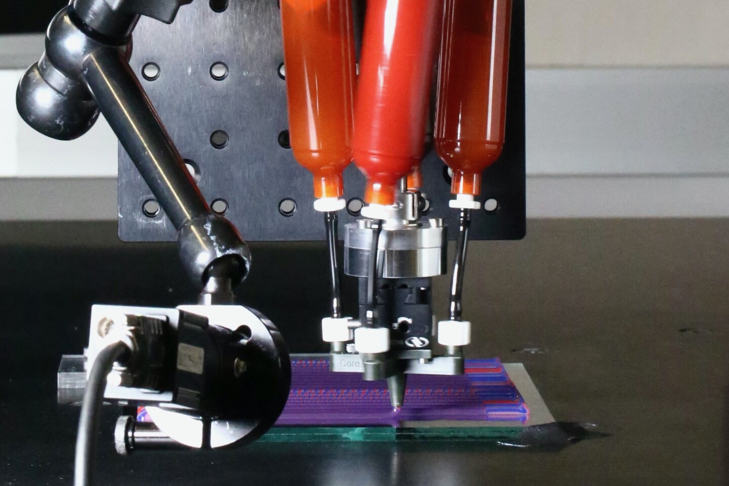 The rig used to produce the filaments, with the ink cartridges at the top and the rotating nozzle at the bottom