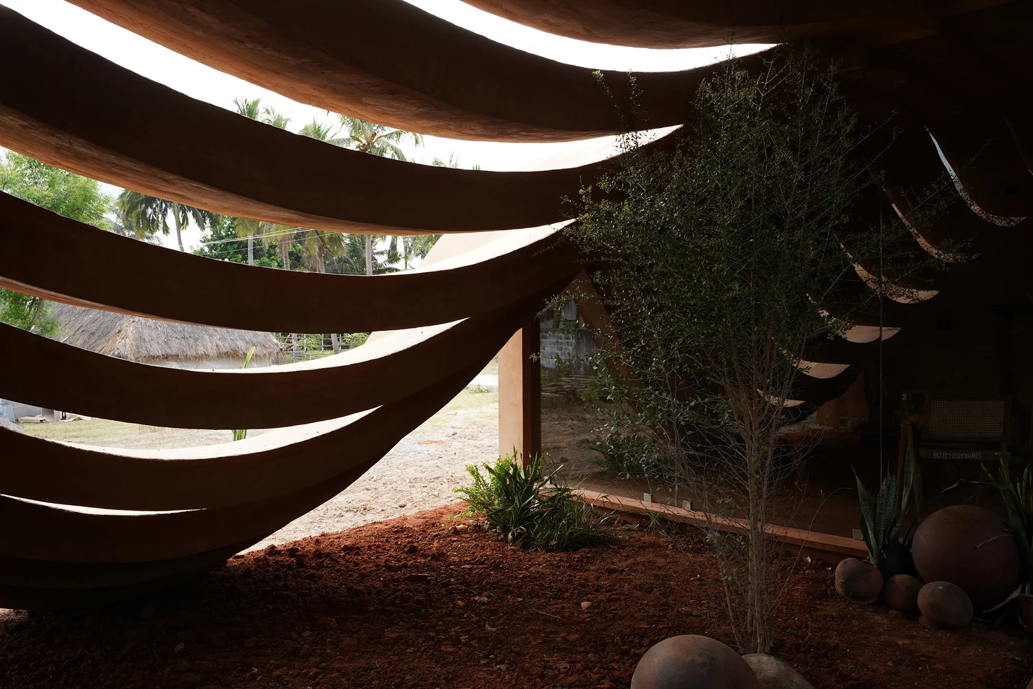 The perforated wall serves as a dynamic climatic buffer, inviting the elements inside