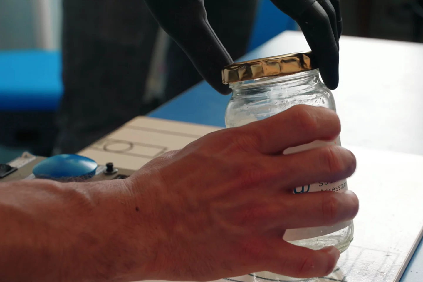 The hand was used to remove a lid from a glass jar