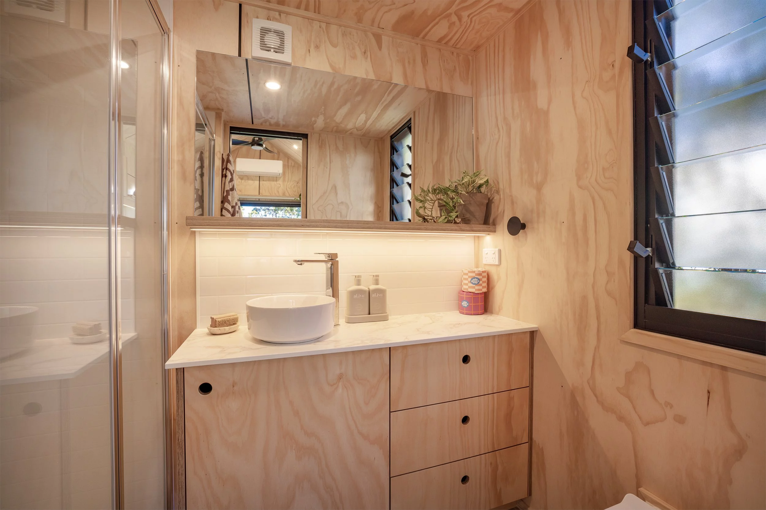 The Five Four's bathroom includes a shower, a vanity sink, and a flushing toilet