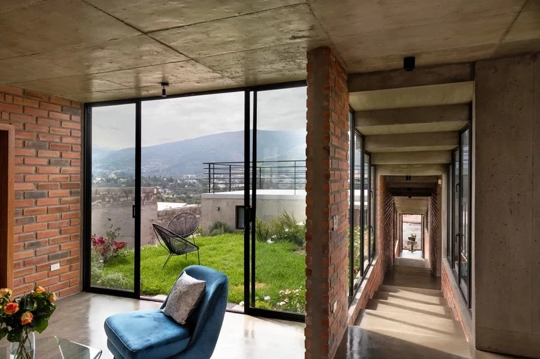 Floor-to-ceiling glass windows encased in black aluminum are featured throughout the home