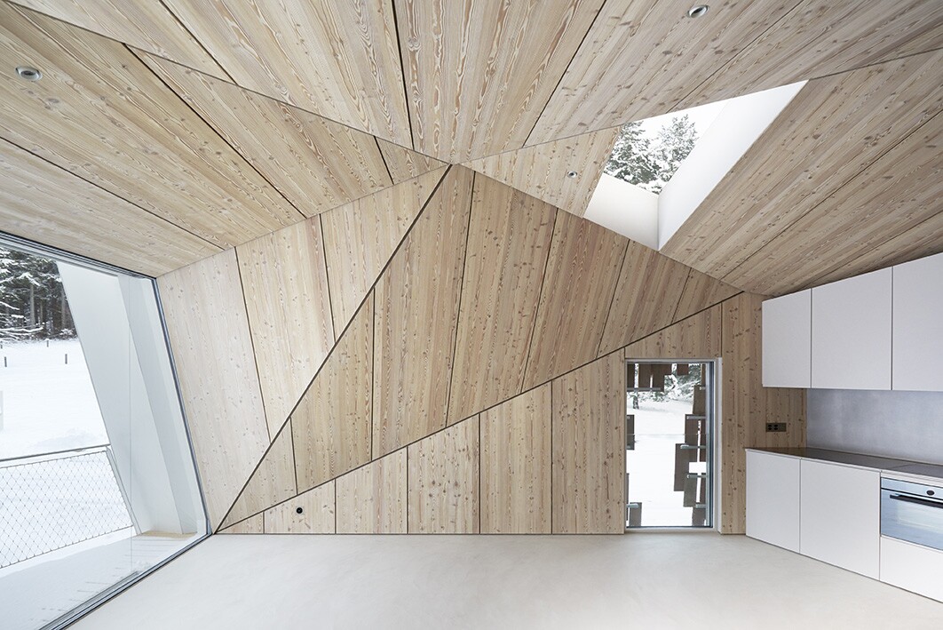 The home includes a large open living and dining area, which opens out to a triangular terrace