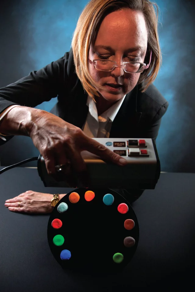 Nerine Cherepy of Lawrence Livermore National Labs (LLNL) displays commercial phosphors (six samples from bottom left of semi-circle) and phosphors being developed by LLNL and collaborators as replacements (five on right)