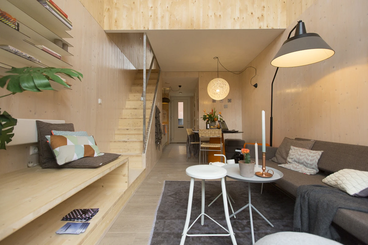 The partly open-plan ground floor includes a kitchen, bathroom, an open-plan lounge area, and a patio outside