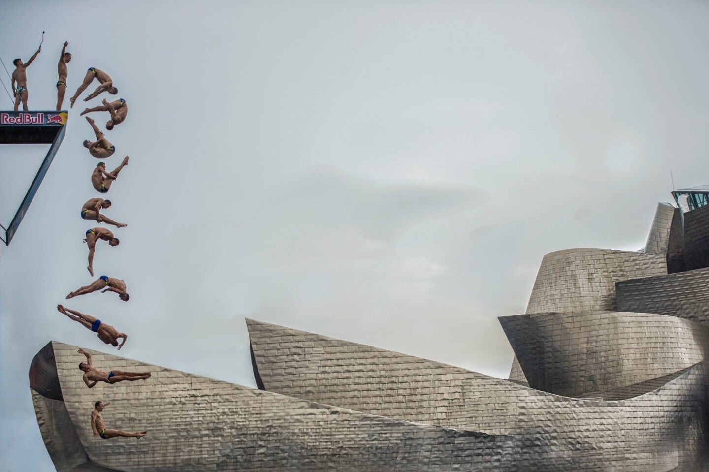 The diver from the Czech Republic, Michal Navrátil, makes one of his jumps next to the Guggenheim Bilbao, as part of the RedBull Cliffdiving world series 2018
