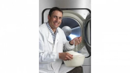 Nathan Wrench, program manager at Cambridge Consultants, and the nylon beads used in the Xeros washing machine (Photo: Xeros)