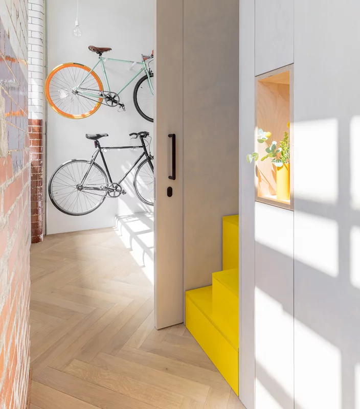 The steps, which give access to the mezzanine, have been painted in bright yellow, adding a playful touch to the home