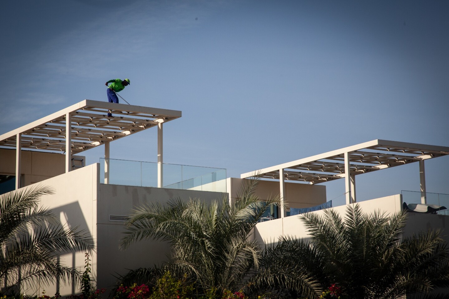 A worker cleans rooftop solar panels at the Dubai Sustainable City