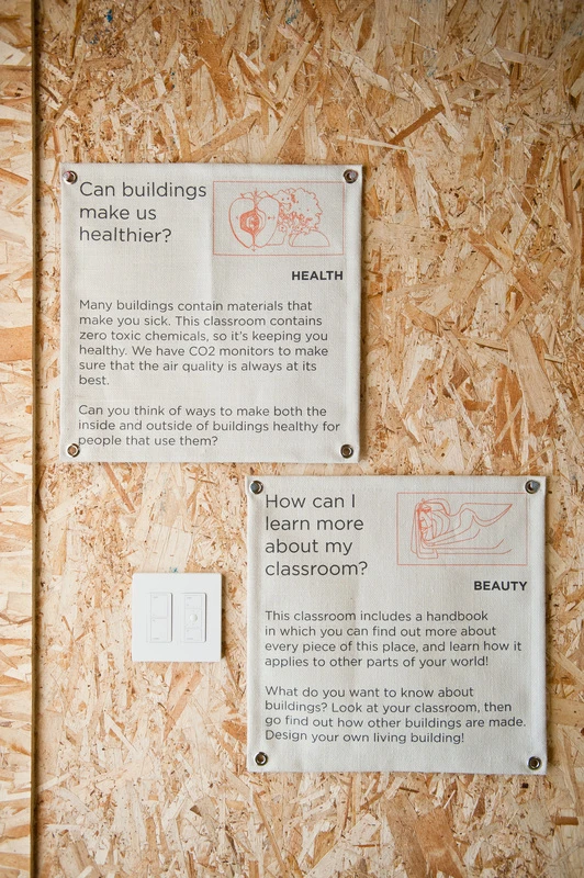 Inside, the classroom looks almost unfinished. The chipboard walls are visible, as are all the ducts, cables, conduits and structural supports, allowing the children to see firsthand how the building works