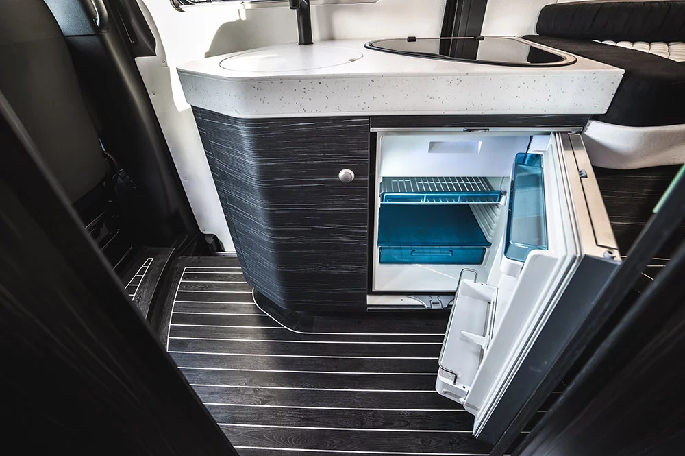 The rounded kitchen edges give way to one of the few rectangles inside the Innova Roadtrip: the fridge